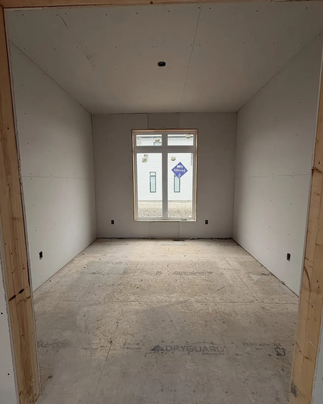 After: the same room with the walls and ceiling hung, the window at the far end.